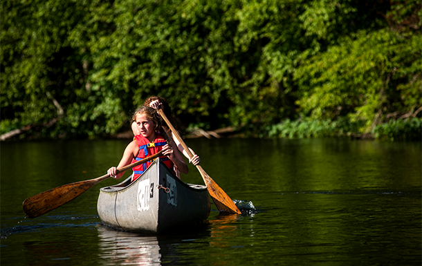 Girl Scouts canoeing on a lake