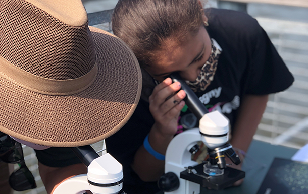 Girl Scout looking through a micoscope