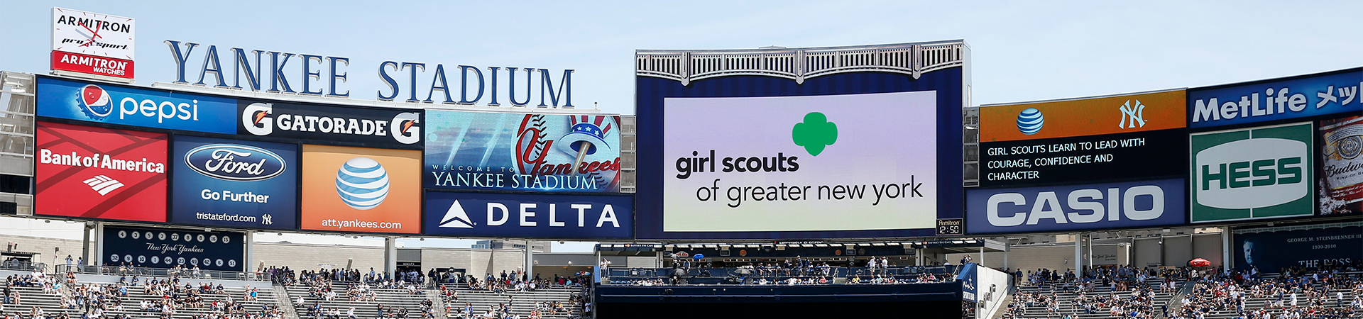  Yankee Stadium stands. Girl Scouts of Greater New York logo displayed on the jumbotron screen. 