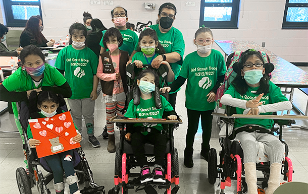 Girl Scouts at a troop meeting in a school cafeteria