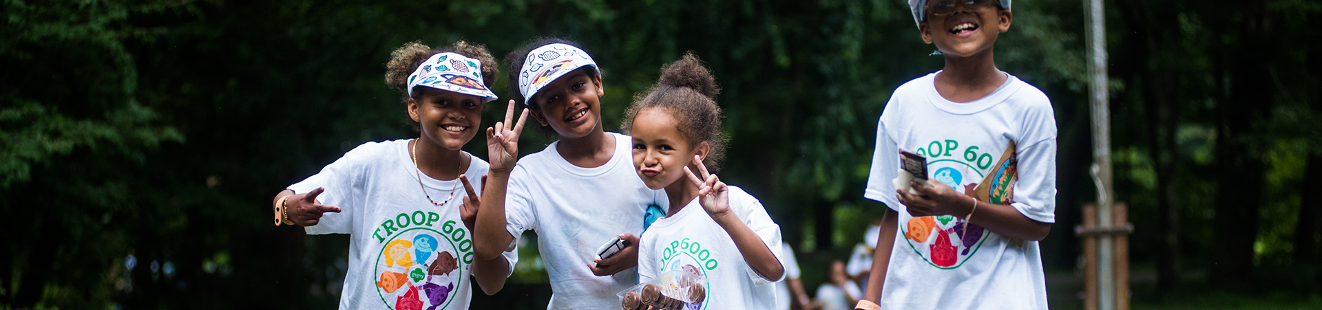  Girl Scout wearing a troop 6000 tshirts smiling outside 