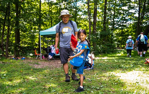 adult woman girl scout volunteer wearing vest outdoors smiling hiking