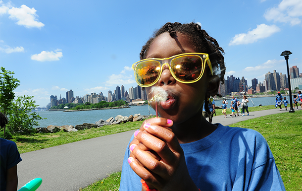 girl scout with digital camera outside wearing trefoil baseball cap