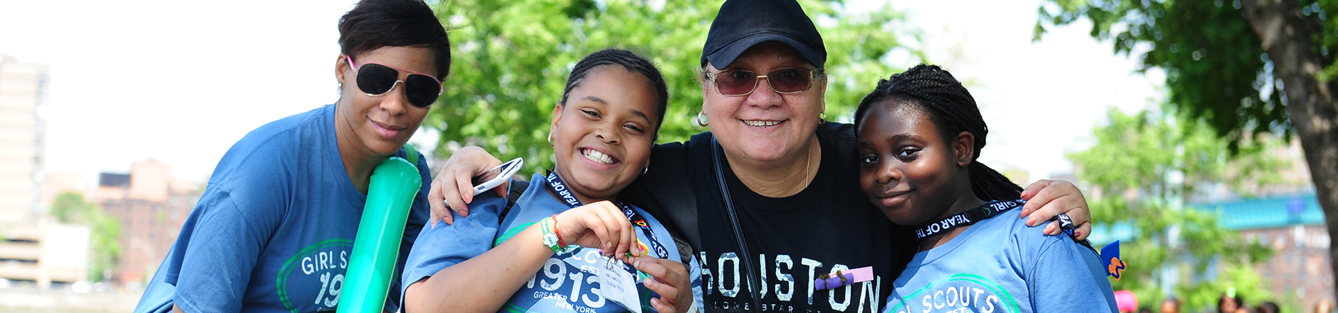  black family with mom, dad, and young daughter outside smiling 