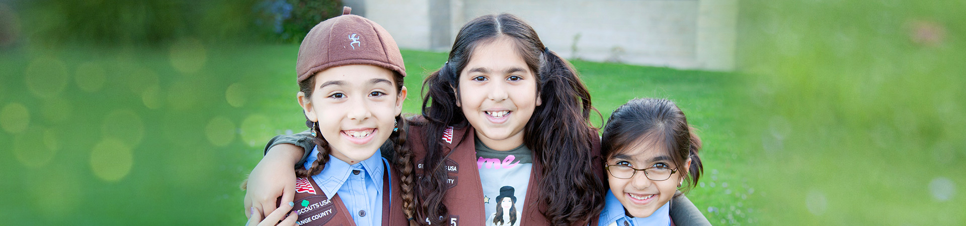  group of brownie girl scouts in uniform outside smiling 